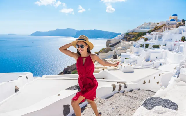 Woman running up stepps in Oia, Santorini in Greece